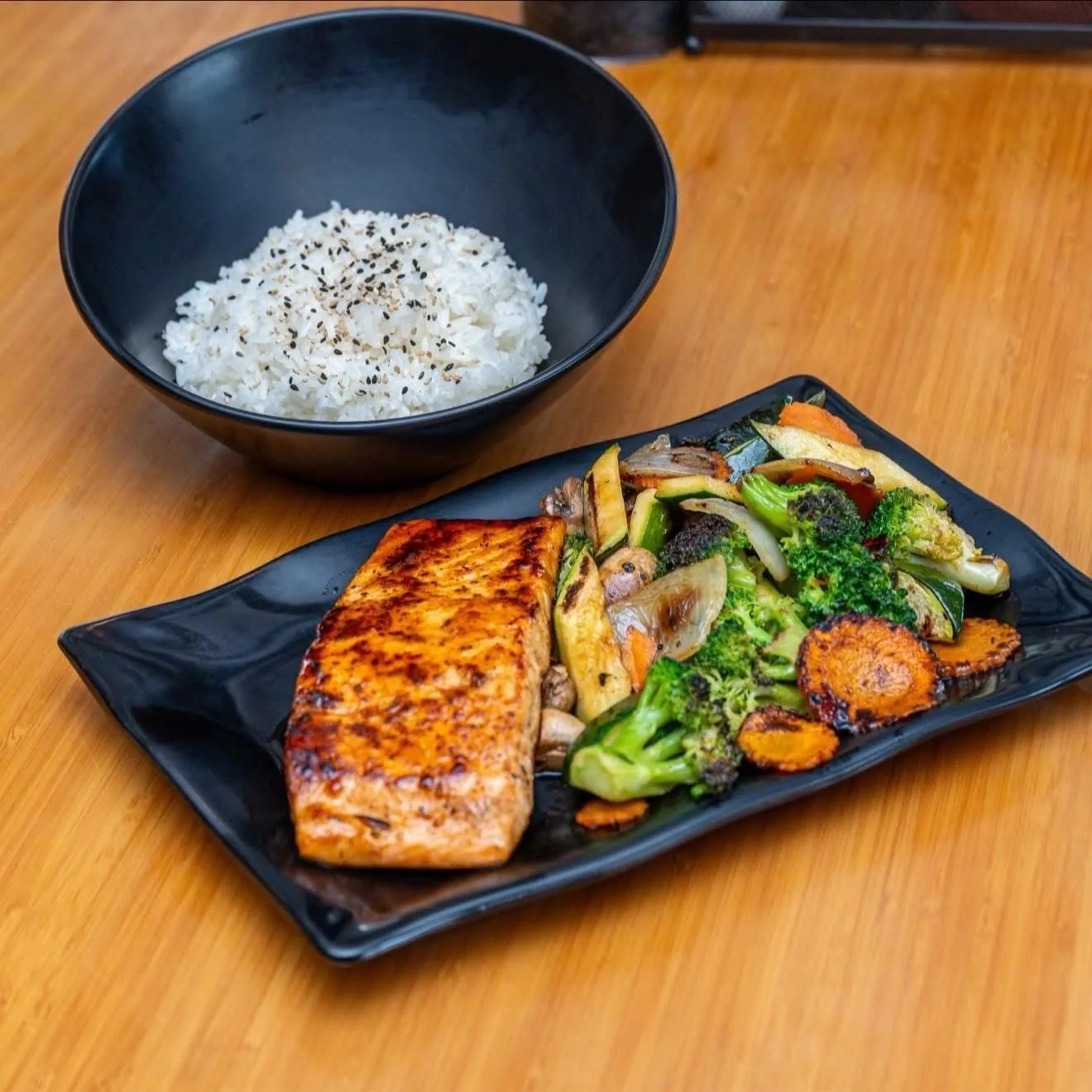 A grilled salmon plate with rice and vegetables